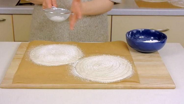 Kuchen mit Mehl bestreuen