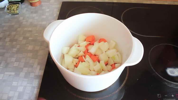 Zwiebeln und Karotten in die Pfanne geben