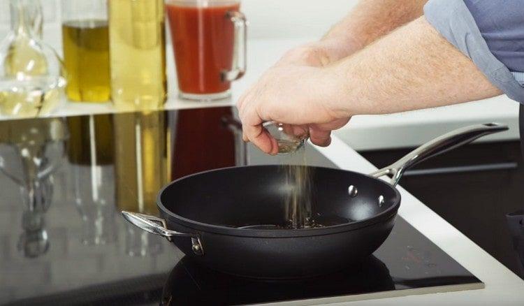 ρίξτε το φυτικό έλαιο στο τηγάνι, προσθέστε ρίγανη και κύμινο.