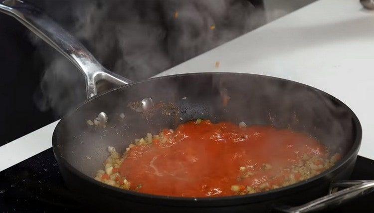Į keptuvę su trintuvu supilkite susmulkintą pomidorą.