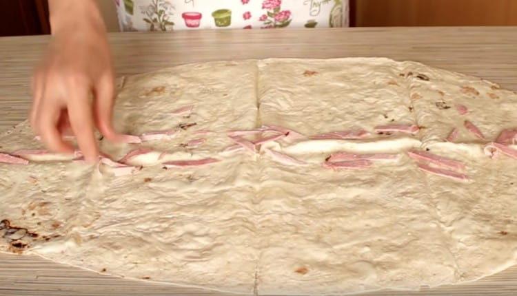 βάλτε ψιλοκομμένο λουκάνικο ή λουκάνικα στο κέντρο του ψωμιού πίτας.