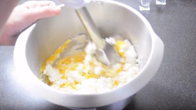 Προσθέστε τους κρόκους και ανακατέψτε ξανά το τυρί cottage.