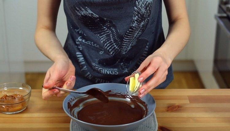 В получената шоколадова глазура добавете маслото, разбъркайте.