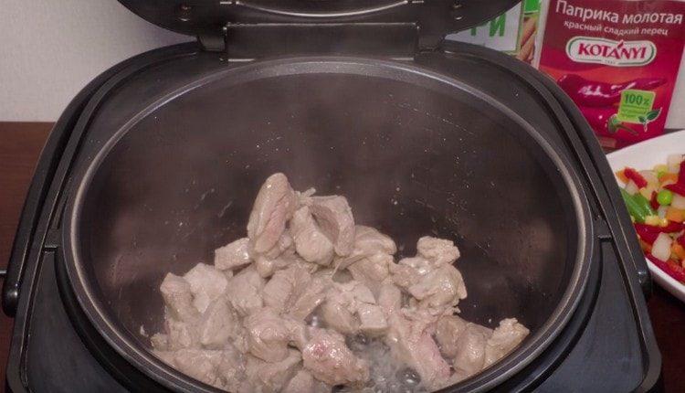 Friggere la carne in una pentola a cottura lenta con il coperchio aperto.