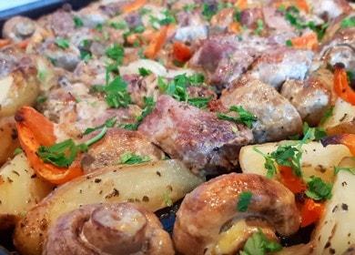 Ofen mit Kartoffeln,  Fleisch und Pilzen im Ofen