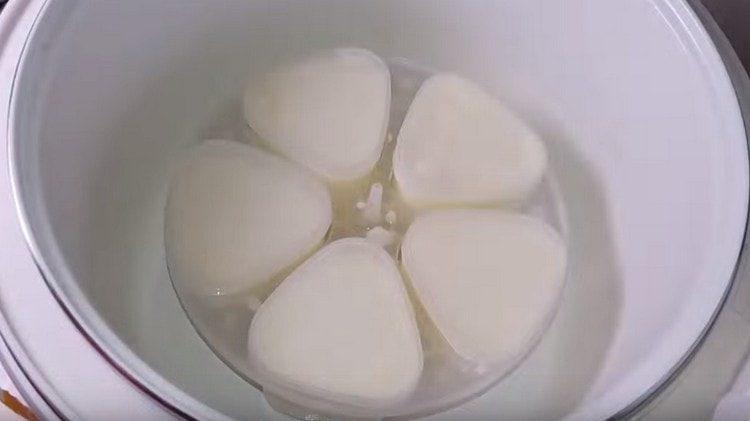 Mettiamo gli stampi nella pentola a cottura lenta e attiviamo la modalità di cottura dello yogurt.