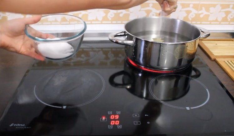 In einem Topf das Wasser zum Kochen bringen, salzen, Pfefferkörner und Lorbeerblatt hinzufügen.