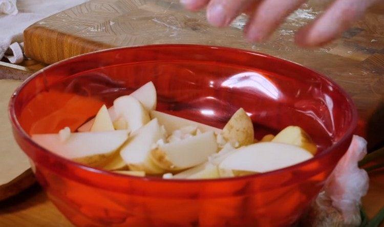 Vložte zemiaky do misy, pridajte nakrájaný cesnak.