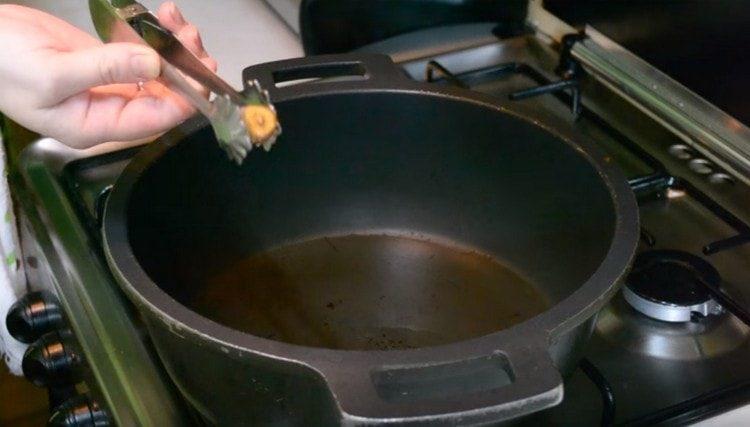 Per controllare il riscaldamento dell'olio, friggere lo spicchio d'aglio e rimuoverlo quando è dorato.