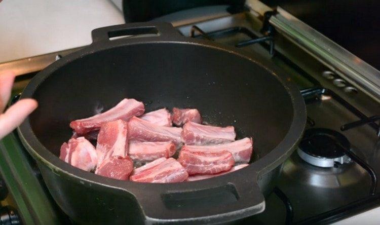 Nell'olio caldo, immergi le costolette di maiale.