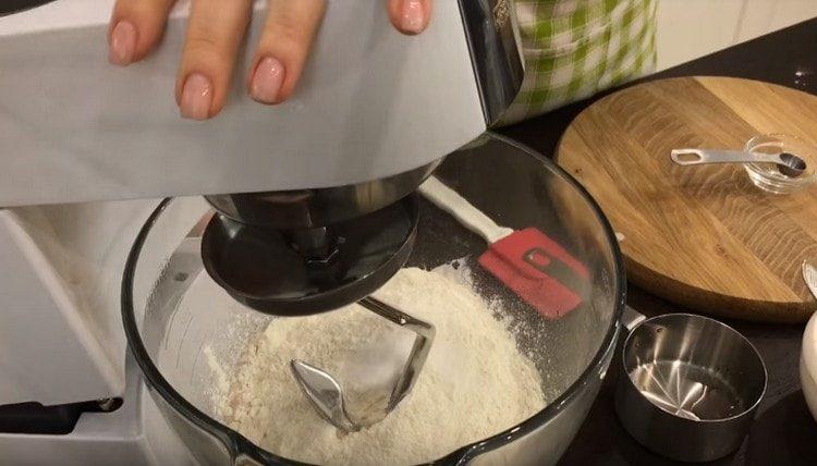 Разпределяме тестото в купа или купа на миксера, добавяме вода и брашно.