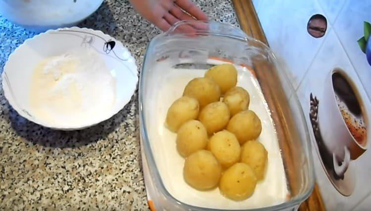 Vložte vařené brambory do pekáče.