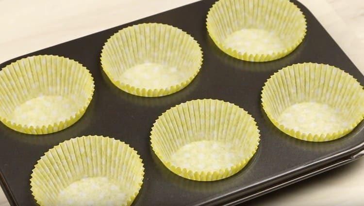 Wir legen spezielle Papierformen in Muffinformen.