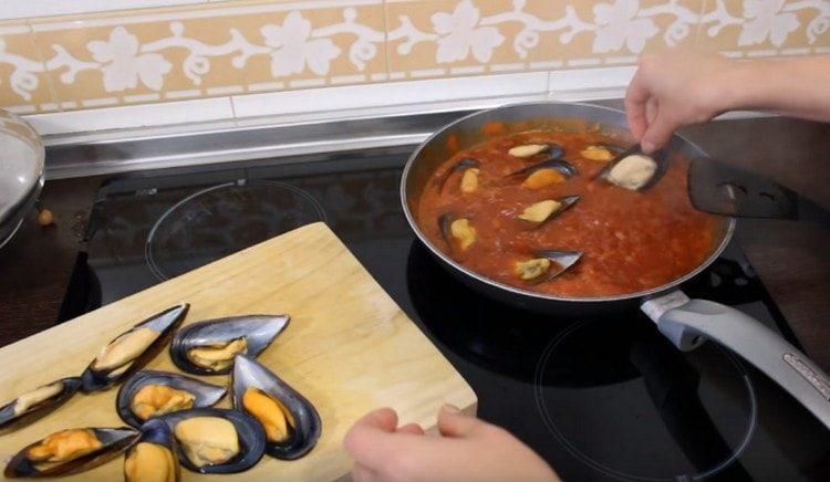 Разстиламе мидите в доматен сос и оставяме да къкри още няколко минути под капака.