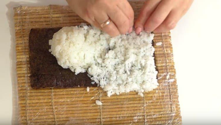 βάλτε ρύζι σε φύλλο nori και κατανέμετε ομοιόμορφα.