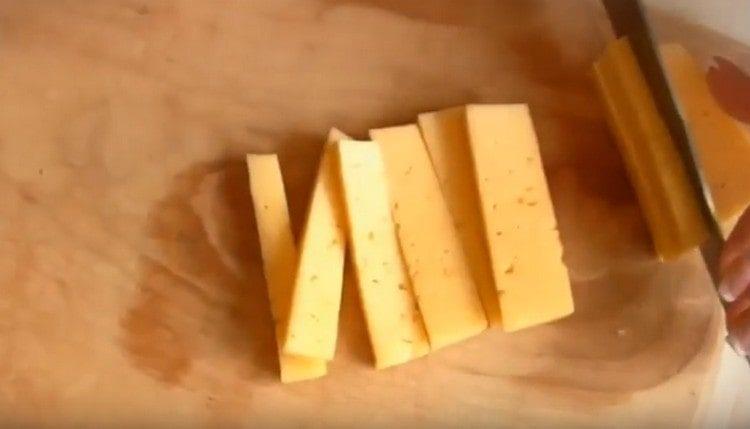 нарязваме твърдото сирене на тънки пръчици.