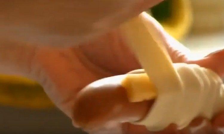 Τυλίξτε το λουκάνικο με δύο κομμάτια τυριού με ζύμη.