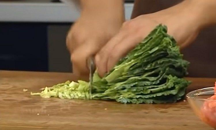 Κόψτε τα φύλλα λάχανου και εξαπλώστε στη σούπα.