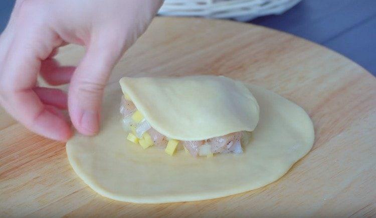 Distribuire il ripieno su una torta più grande e coprirlo con un pezzo di pasta più piccolo.